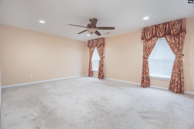 carpeted spare room featuring ceiling fan