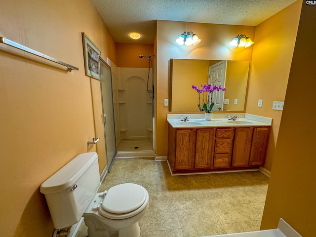 bathroom with tile patterned flooring, a shower, a textured ceiling, double vanity, and toilet