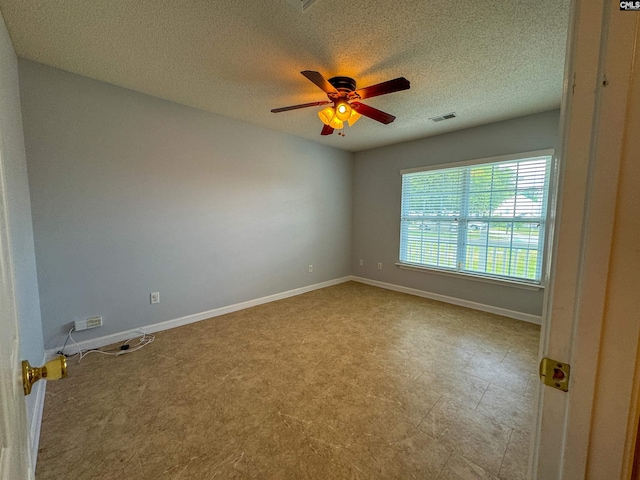 tiled spare room featuring a textured ceiling and ceiling fan