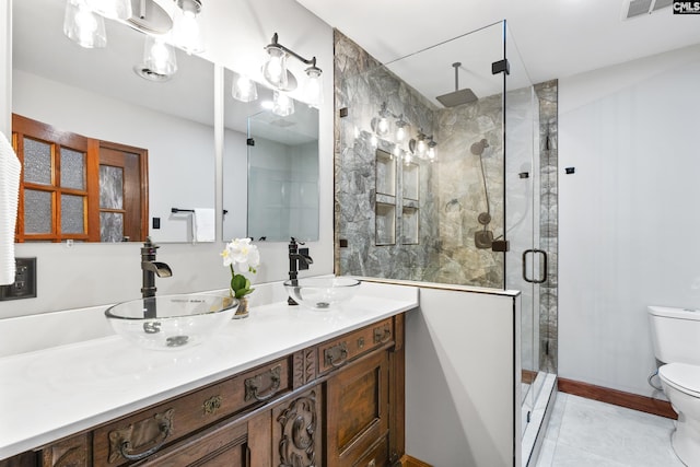 bathroom featuring tile patterned flooring, vanity, toilet, and a shower with shower door