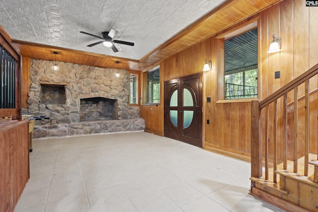 tiled living room featuring ceiling fan with notable chandelier, wood walls, wood ceiling, and lofted ceiling