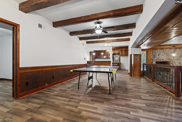 tiled entrance foyer featuring a stone fireplace, wood walls, and ceiling fan