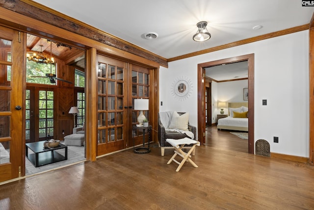 sitting room with french doors, an inviting chandelier, ornamental molding, and hardwood / wood-style flooring