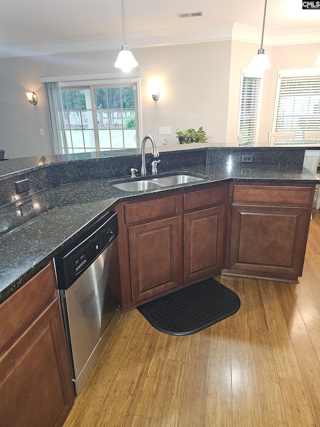 kitchen with a sink, visible vents, light wood-style floors, dishwasher, and crown molding