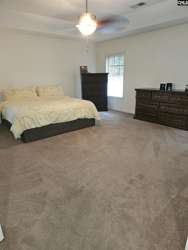 bedroom with visible vents, a ceiling fan, and light colored carpet