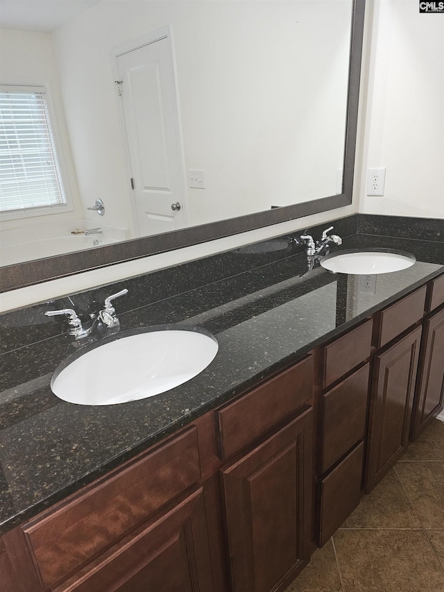 full bath with double vanity, tile patterned flooring, and a sink