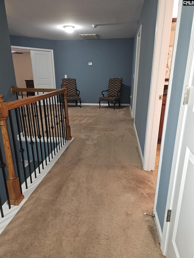 hallway featuring carpet floors, visible vents, and baseboards