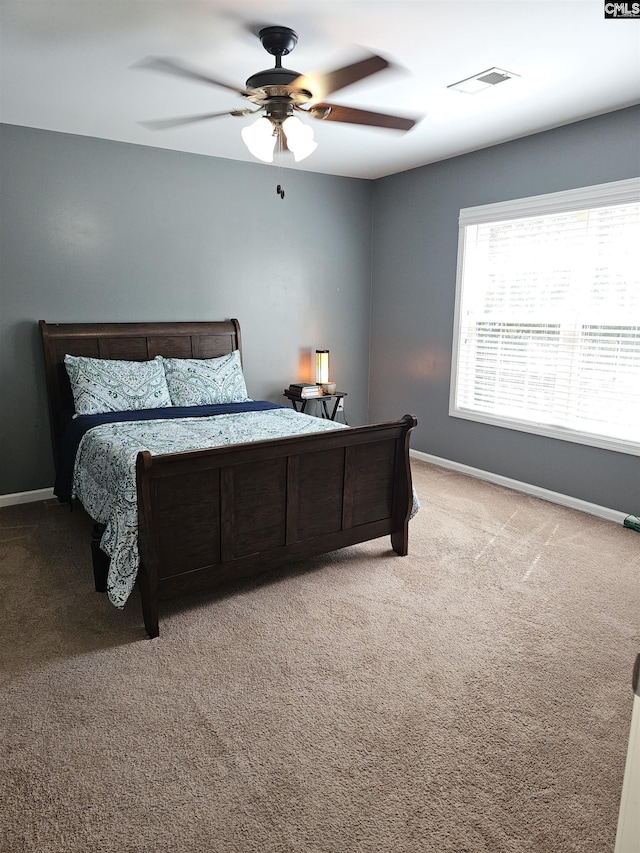 carpeted bedroom featuring visible vents, ceiling fan, and baseboards