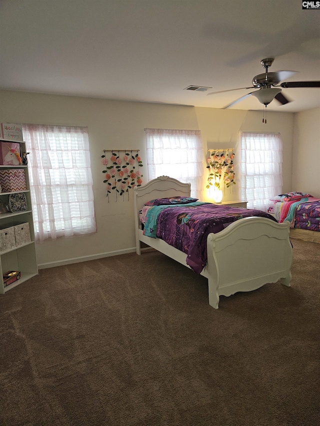 carpeted bedroom featuring ceiling fan, visible vents, and baseboards