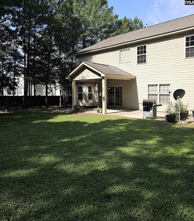 rear view of house featuring a yard and a patio