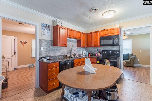 kitchen with black appliances, decorative backsplash, crown molding, sink, and light hardwood / wood-style flooring