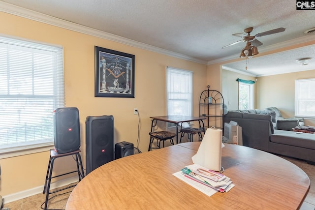 dining area featuring a textured ceiling, ceiling fan, and crown molding