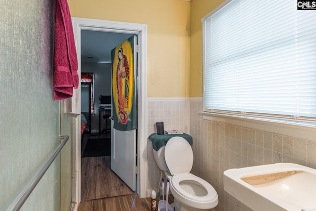 bathroom featuring tile walls, toilet, and hardwood / wood-style floors