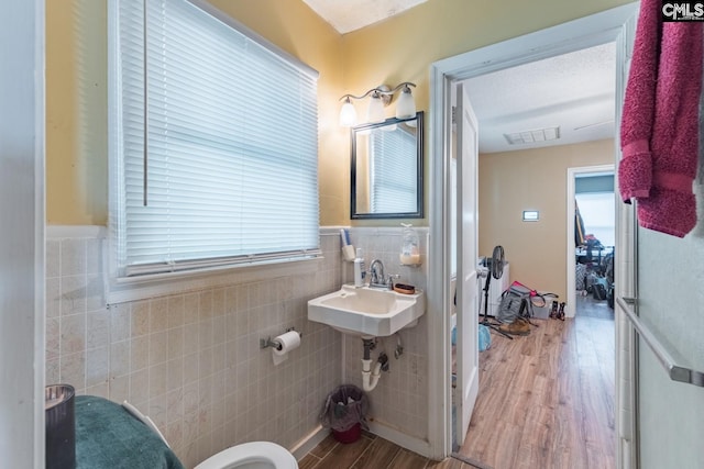 bathroom featuring tile walls, toilet, hardwood / wood-style floors, and sink