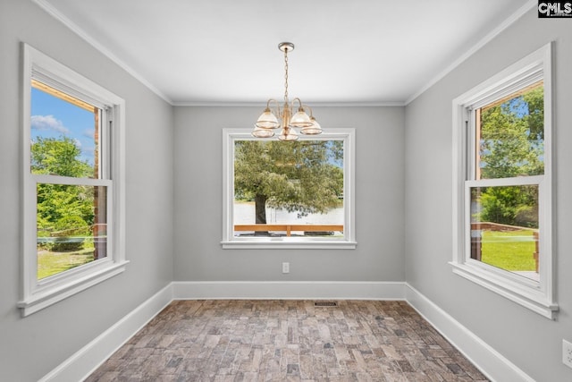 unfurnished room featuring a notable chandelier, crown molding, and plenty of natural light