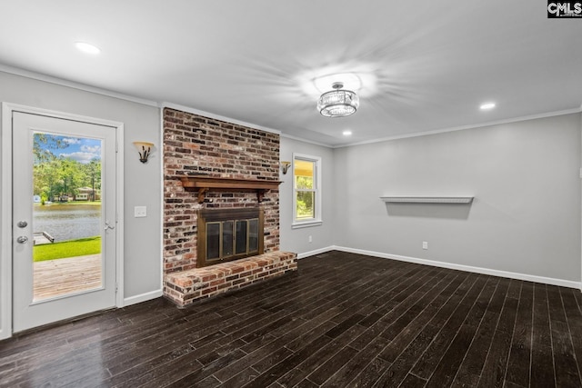 unfurnished living room with a fireplace, ornamental molding, and dark hardwood / wood-style floors