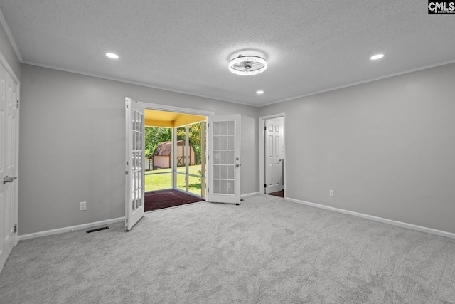 carpeted empty room featuring ornamental molding, french doors, and a textured ceiling