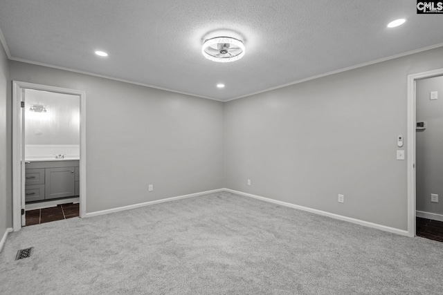 interior space with crown molding, carpet floors, a textured ceiling, and ensuite bathroom