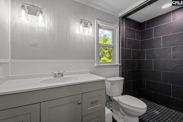 bathroom with ornamental molding, toilet, vanity, and a tile shower