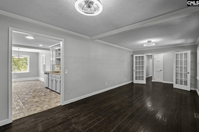 empty room with crown molding, dark hardwood / wood-style floors, french doors, and a textured ceiling