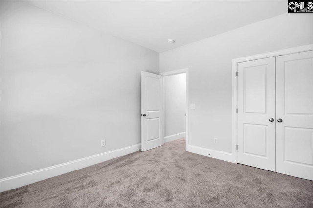 unfurnished bedroom featuring carpet flooring, baseboards, and a closet