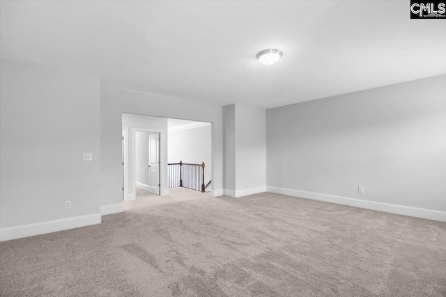 spare room with baseboards and carpet