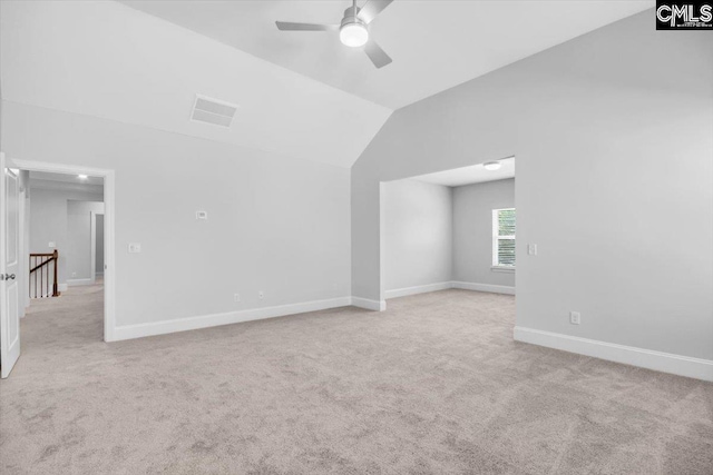 empty room featuring a ceiling fan, baseboards, visible vents, lofted ceiling, and light carpet