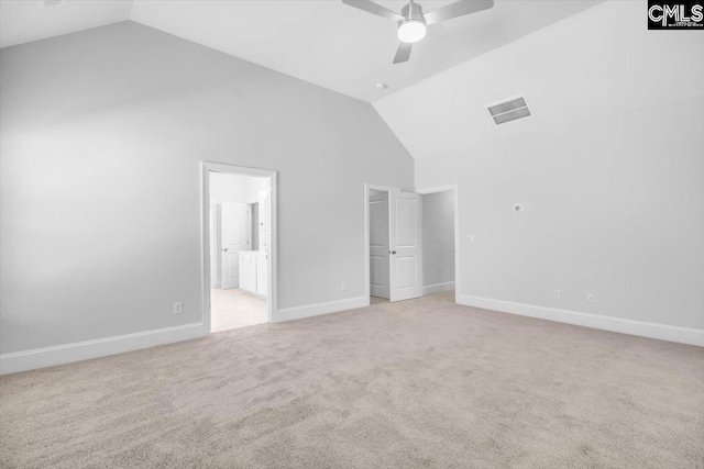 unfurnished bedroom with light colored carpet, high vaulted ceiling, ensuite bathroom, and baseboards