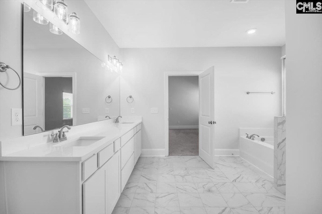 full bathroom featuring marble finish floor, a garden tub, baseboards, and a sink