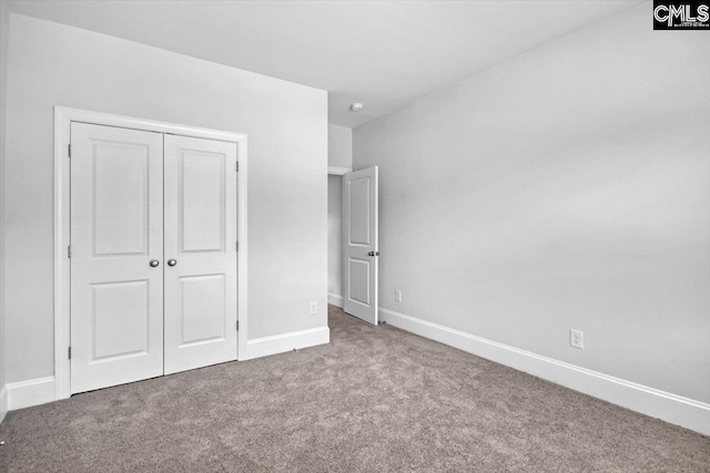 unfurnished bedroom with carpet, baseboards, and a closet