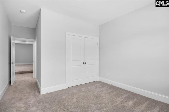 unfurnished bedroom with a closet, baseboards, and carpet floors