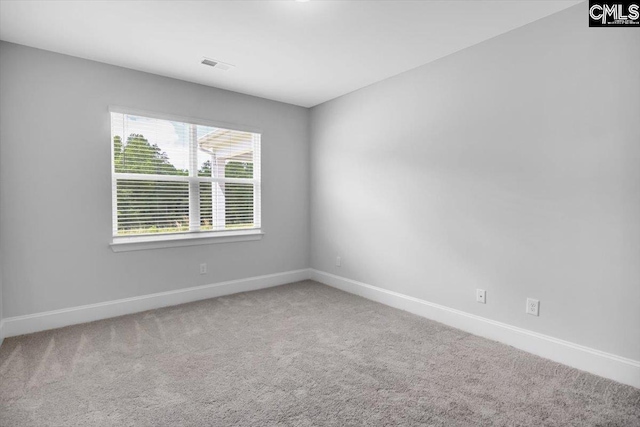 carpeted empty room featuring visible vents and baseboards