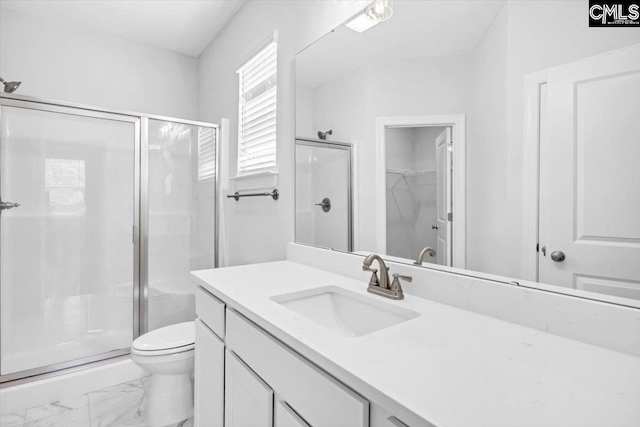 full bath featuring a shower stall, a walk in closet, toilet, marble finish floor, and vanity