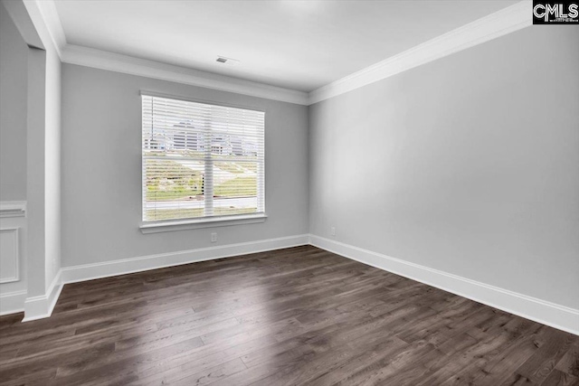 empty room with dark wood-style flooring, baseboards, and ornamental molding