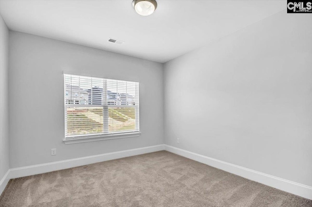 carpeted empty room with visible vents and baseboards