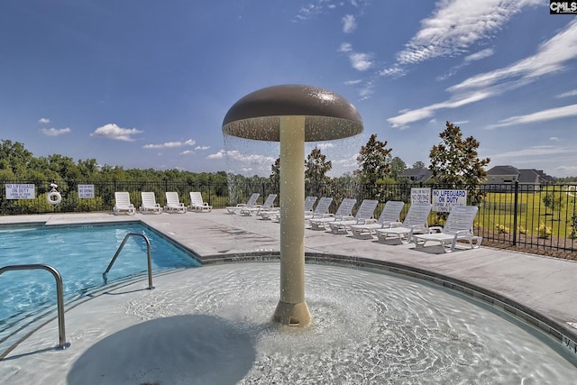 community pool featuring fence and a patio area