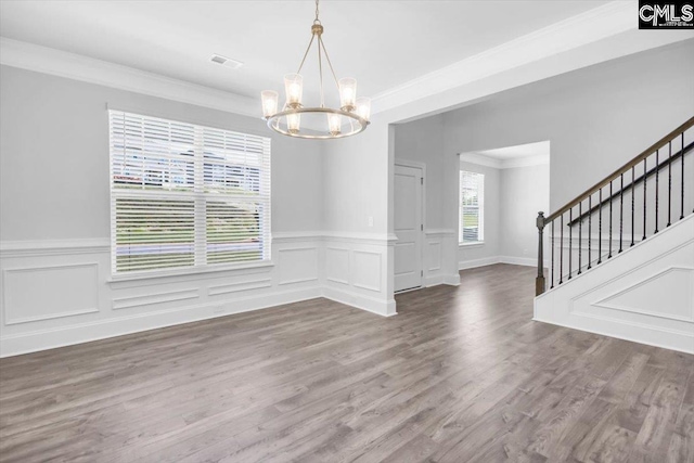 unfurnished dining area featuring visible vents, stairway, ornamental molding, wood finished floors, and a notable chandelier