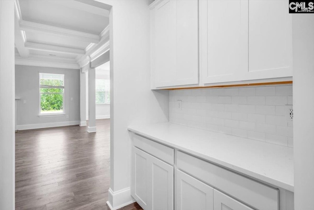 interior space featuring baseboards, ornamental molding, and dark wood-style flooring