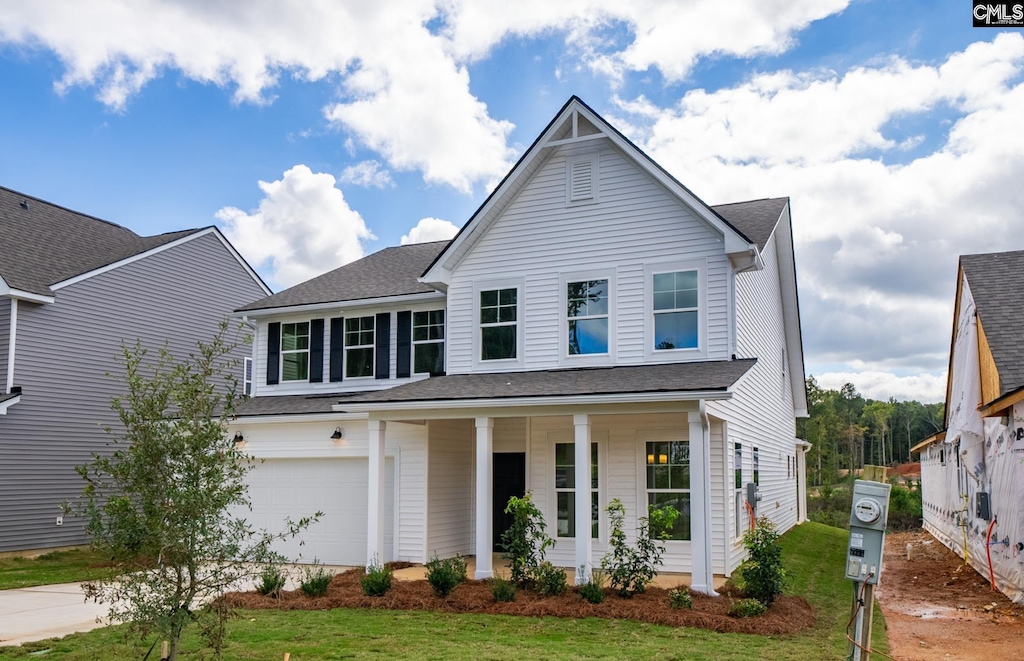 view of front of property with a porch, a garage, and a front yard