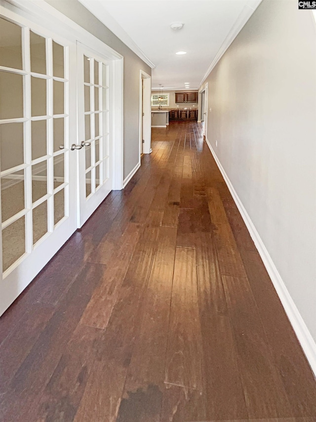 hallway featuring french doors, dark hardwood / wood-style floors, and ornamental molding