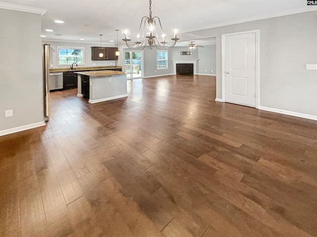 unfurnished dining area featuring crown molding, ceiling fan with notable chandelier, dark hardwood / wood-style floors, and sink