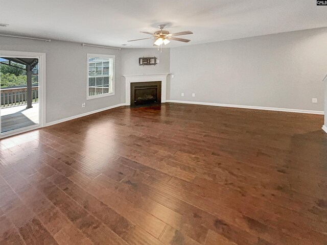 unfurnished living room with ceiling fan and dark wood-type flooring