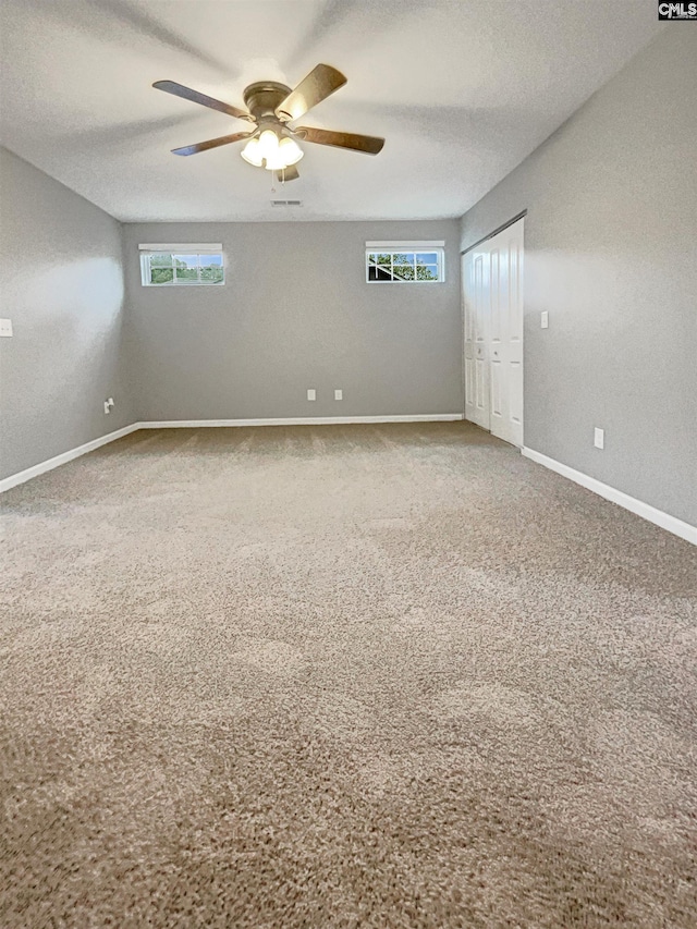 unfurnished room featuring ceiling fan, a textured ceiling, and carpet flooring