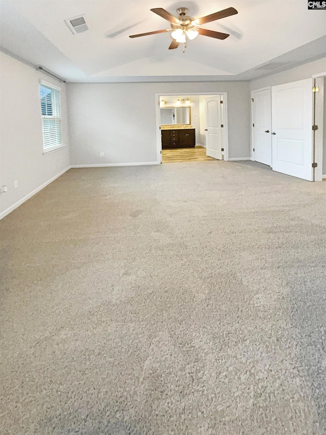 interior space with ceiling fan, vaulted ceiling, and carpet floors