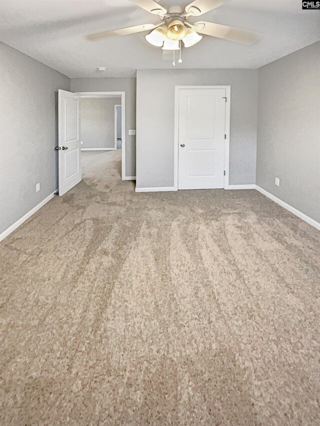 carpeted empty room with ceiling fan and a textured ceiling