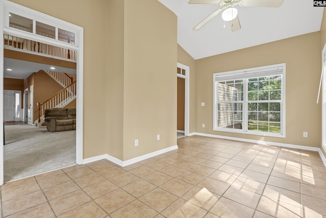 tiled empty room with high vaulted ceiling and ceiling fan