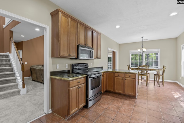 kitchen with decorative light fixtures, light carpet, kitchen peninsula, a chandelier, and appliances with stainless steel finishes