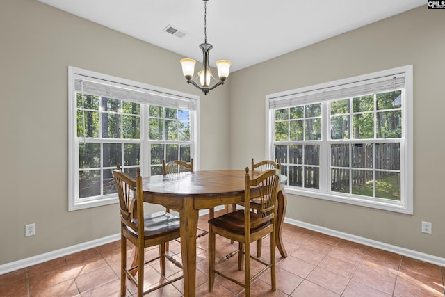 tiled dining room with an inviting chandelier