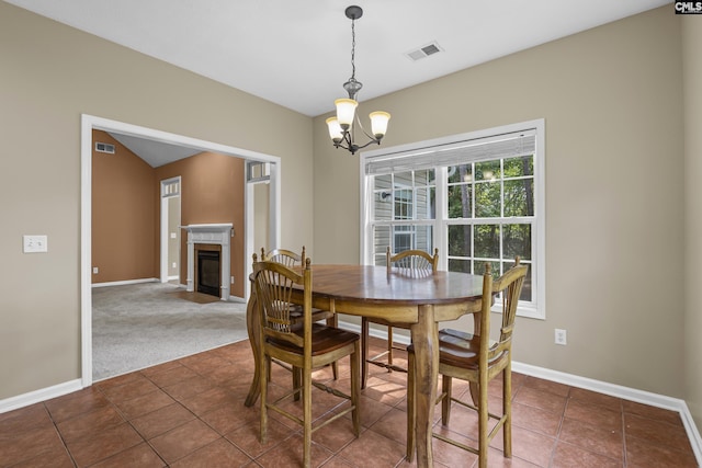 dining space featuring dark tile patterned floors and a chandelier