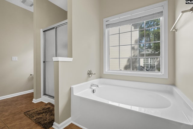 bathroom with a healthy amount of sunlight, separate shower and tub, and tile patterned flooring